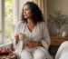 A 53-year-old woman sitting quietly beside a window and reflecting on her changing menstrual cycle during perimenopause.